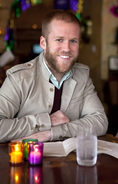 stock image Young happy man at the restaurant table.