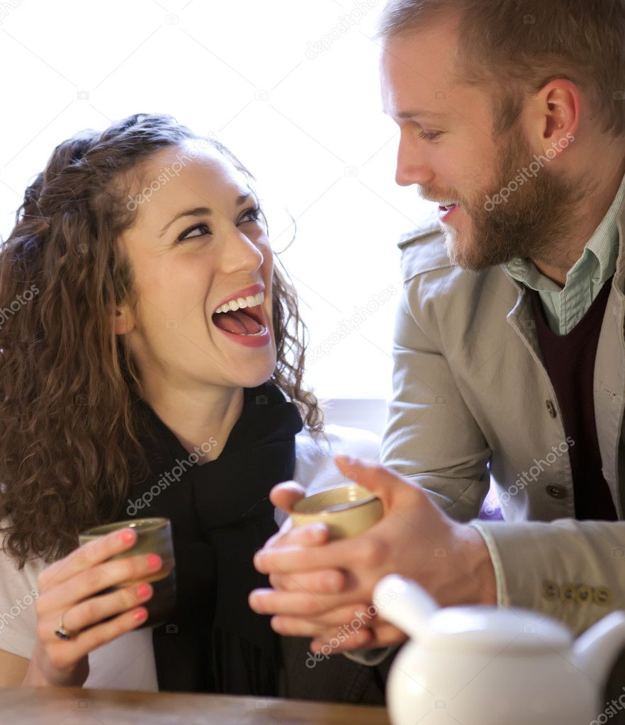 Young couple drinking tea and laughing.