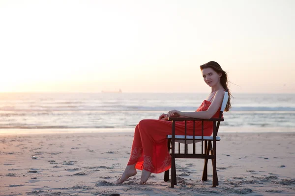 Hermosas sus mujeres en la playa sentado en silla . — Foto de Stock