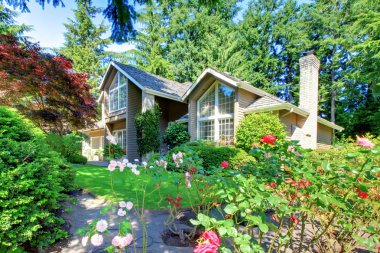 Beautiful green front garden with brown house. clipart