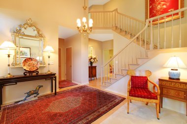 Luxury entrance living room with red rug, staircase. clipart