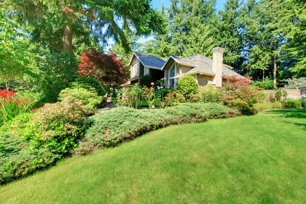 Hermoso jardín delantero verde con casa marrón . —  Fotos de Stock