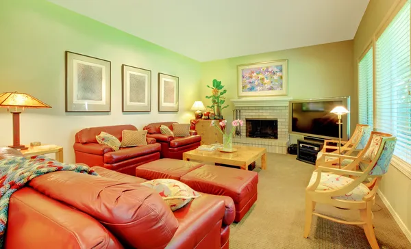 Большая гостиная с кожаными диванами, камином и телевизором — стоковое фото