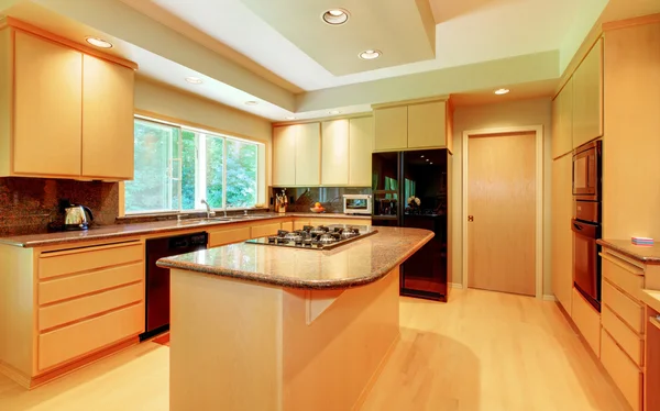 Große Küche mit Honigholz und schwarzen Geräten. — Stockfoto