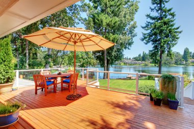 Large deck with umbrella and view of the lake clipart