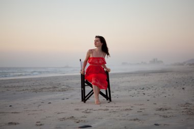 genç güzel kadın plaj sandalye üzerinde oturan.