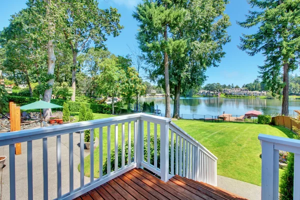 Deck with white railings and lake view over large lot. — Stock Photo, Image