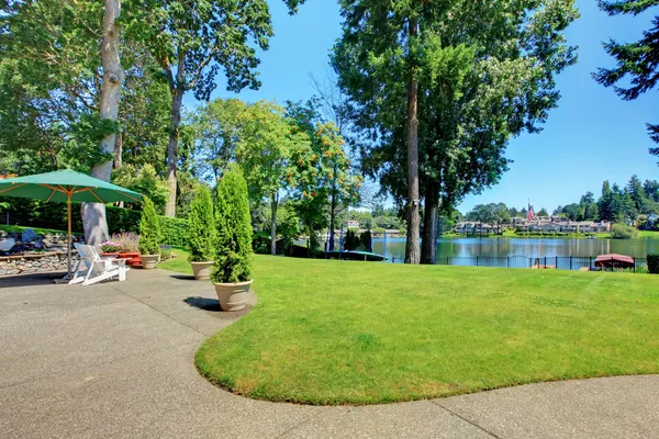 Gran patio trasero con la vista del lago y el área al aire libre . — Foto de Stock