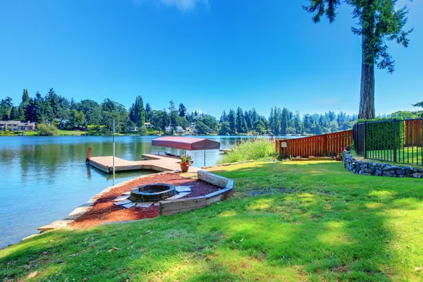 Back yard with lake and dock and fire pit — Stock Photo, Image