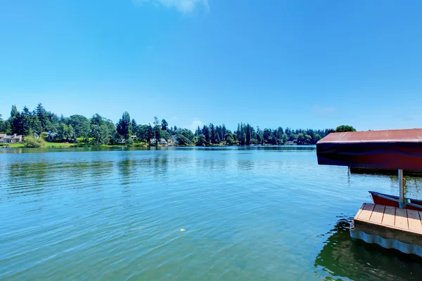 Jezioro objęte dock i widok na domy. — Zdjęcie stockowe