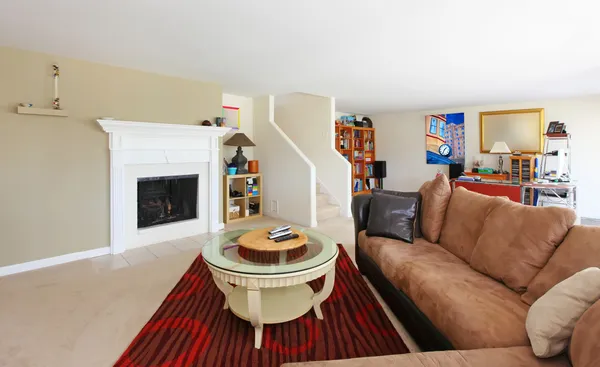 Källaren vardagsrum med öppen spis och brun soffa — Stockfoto