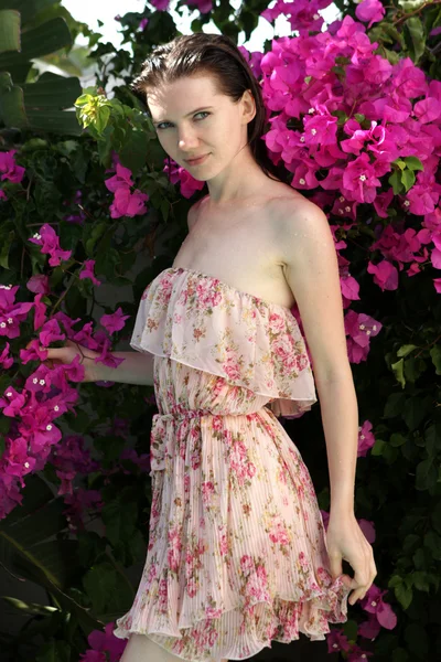 Young beautiful woman near the flowering bush. — Stock Photo, Image