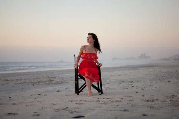 Stock image Young beautiful woman is sitting on the chair on the beach.