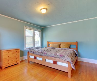 Blue bedroom with oak floor and large bed. clipart