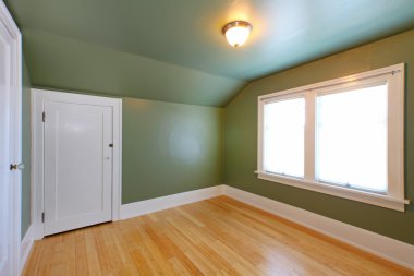 Attic room with green wals and birch hardwood floor. clipart