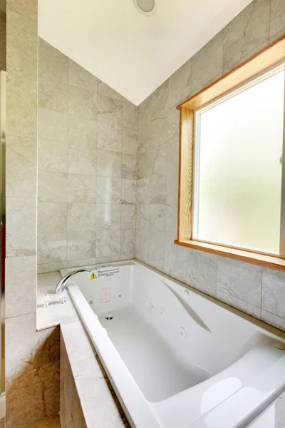 Bañera blanca con ventana grande y azulejos . — Foto de Stock
