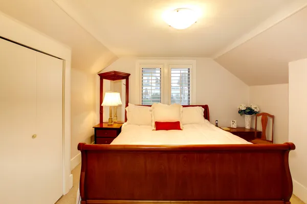 Malá ložnice s nízkým stropem a velká postel — Stock fotografie