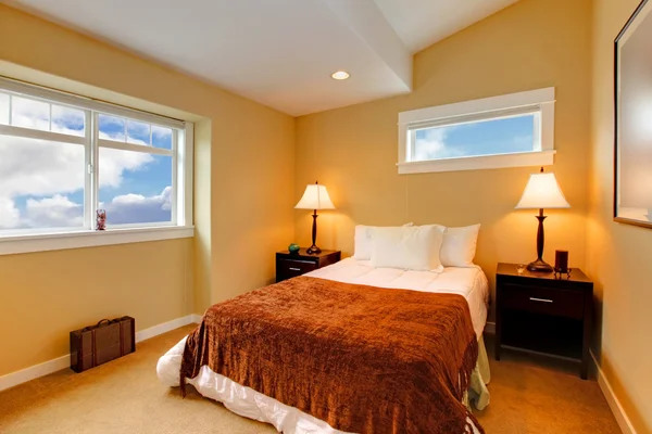 Dormitorio con pintura de mostaza amarilla y ropa de cama marrón — Foto de Stock
