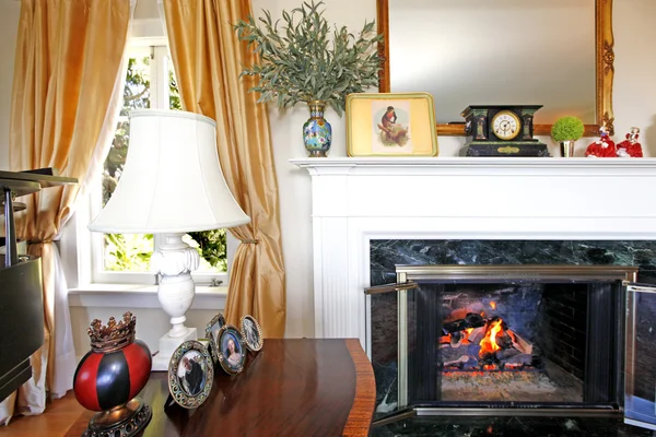 窓の近くのテーブルと白のランプが付いている暖炉 — ストック写真
