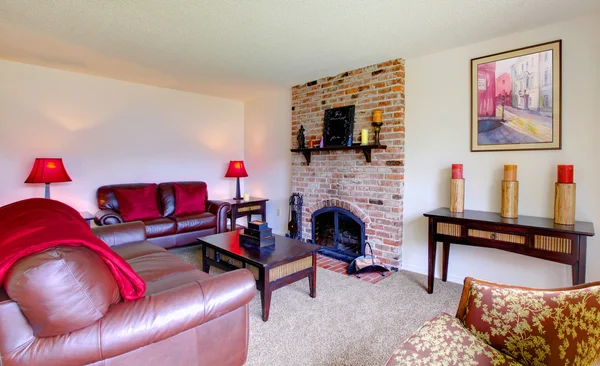 Obývací pokoj s koženými pohovkami a krb s růžová — Stock fotografie