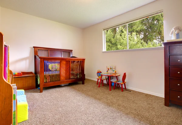 Простая детская комната с дровяной кроваткой — стоковое фото