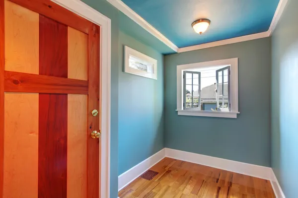 Vlastní dřevěné dveře v modré prázdné místnosti s otevřít okno. — Stock fotografie