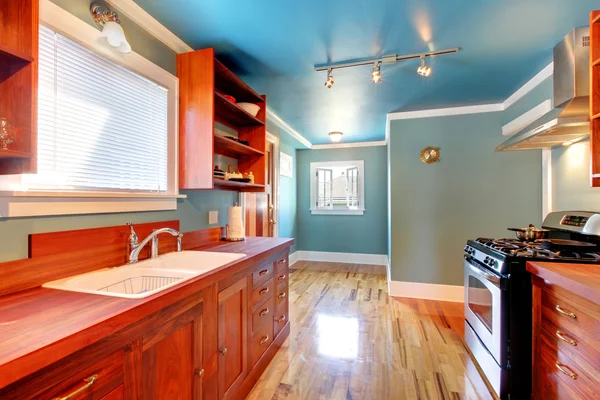 Blauwe keuken met kersen kasten en glanzende vloer. — Stockfoto