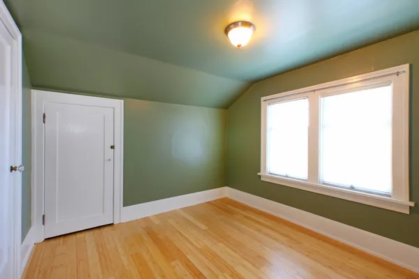 Mansardenzimmer mit grünen Wals und Birkenholzboden. — Stockfoto