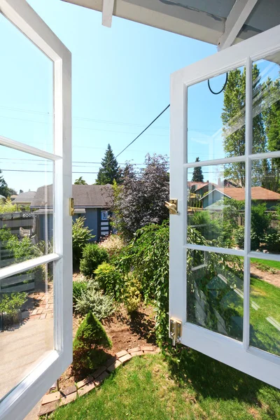 Open venster naar de achtertuin met kleine schuur. — Stockfoto