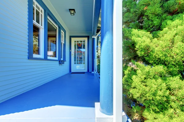 Casa azul coberta varanda frontal com porta de entrada . — Fotografia de Stock