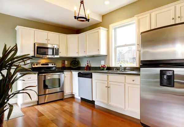Klassieke witte en groene nieuwe keuken met cherry vloer. — Stockfoto