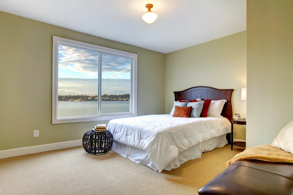 Dormitorio grande verde con cama blanca y vista al agua . —  Fotos de Stock