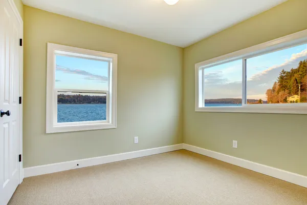 Leere neue Schlafzimmer mit Blick auf das Wasser, grüne Wände. — Stockfoto