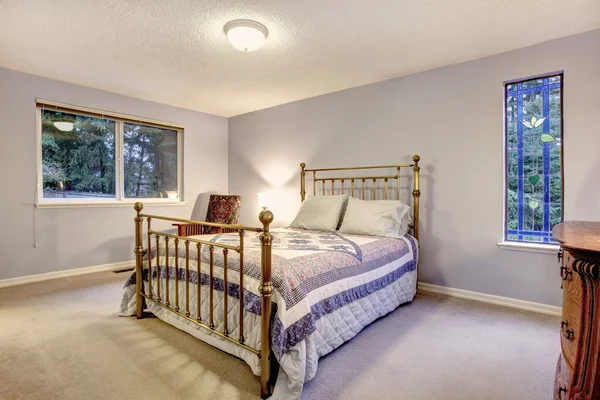 Blaues einfaches Schlafzimmer mit Metallgestell-Bett. — Stockfoto