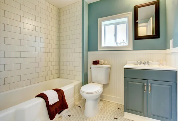 Neues umgebautes blaues Badezimmer mit klassischer weißer Fliese. Stockbild
