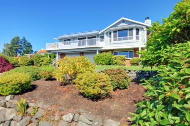 Two story American house with large deck and two garages. clipart