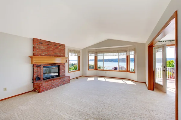 Sala de estar brilhante com lareira de tijolo e vista deck . — Fotografia de Stock