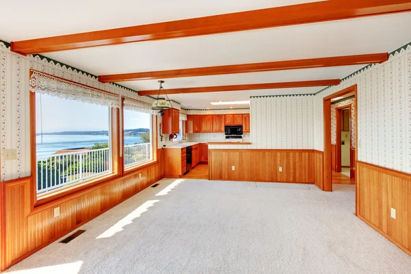 Grote woonkamer met hout trim en keuken bekijken. — Stockfoto