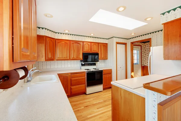 Светлая деревянная уютная кухня с видом на воду и белой столешницей . — стоковое фото