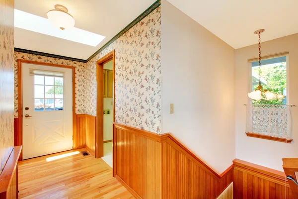 Acogedor pasillo soleado con escalera y puerta principal y madera caliente . — Foto de Stock