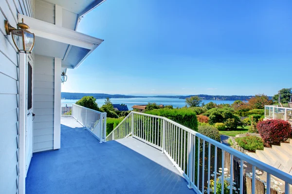 Haustür-Veranda mit Blick auf das Wasser und graues Haus und Buschgrün. — Stockfoto