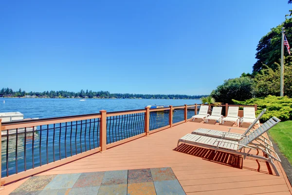 Lake waterfront deck with beach laying down chairs — Stock Photo, Image