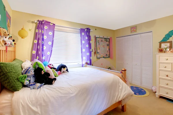 Baby girl pokoj s hračkami a fialové závěsy. — Stock fotografie