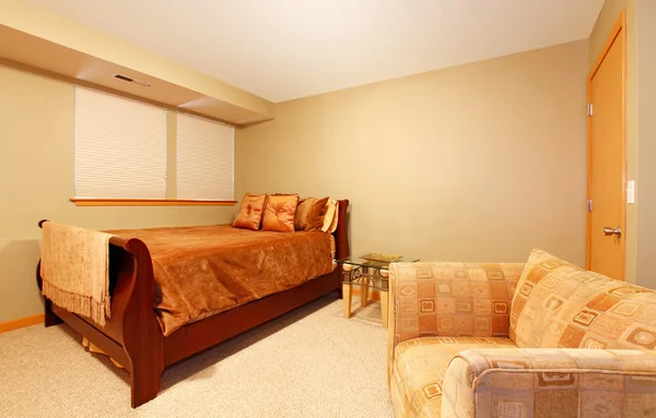Простий рівень підвалу гостьова спальня з ліжком і стільцем . — стокове фото