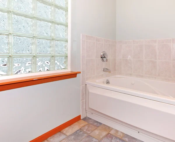 Novo canto do banheiro com janela de bloco de vidro e banheira . — Fotografia de Stock