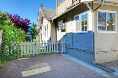 Cute grey house exterior with patio and small fence clipart