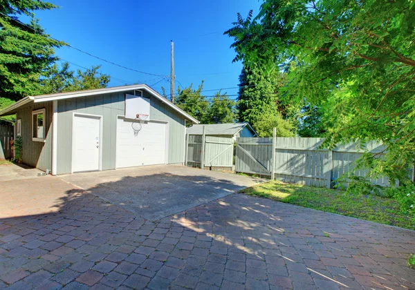 Back yard fenced with garage and paved parking space. — Stock Photo, Image