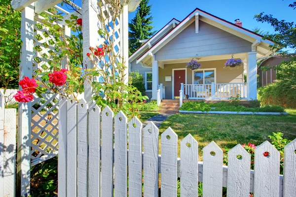 OLd cute grey house exterior behind white fence. — Stock Photo, Image