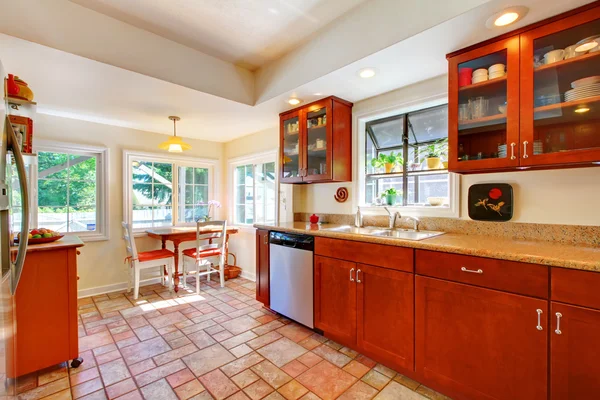 Charming cherry wood kitchen with tile floor. — Stock Photo, Image