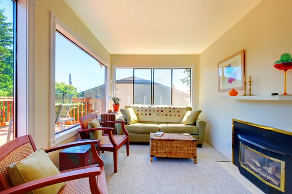 Ljusa soliga vardagsrummet med öppen spis och soffa. — Stockfoto